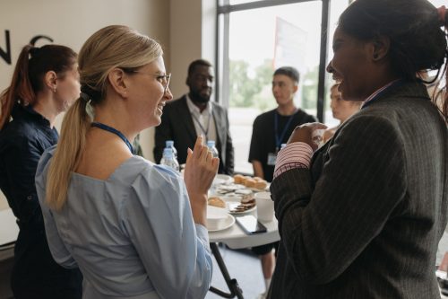 Colleagues engaging in conversation over coffee at a work event